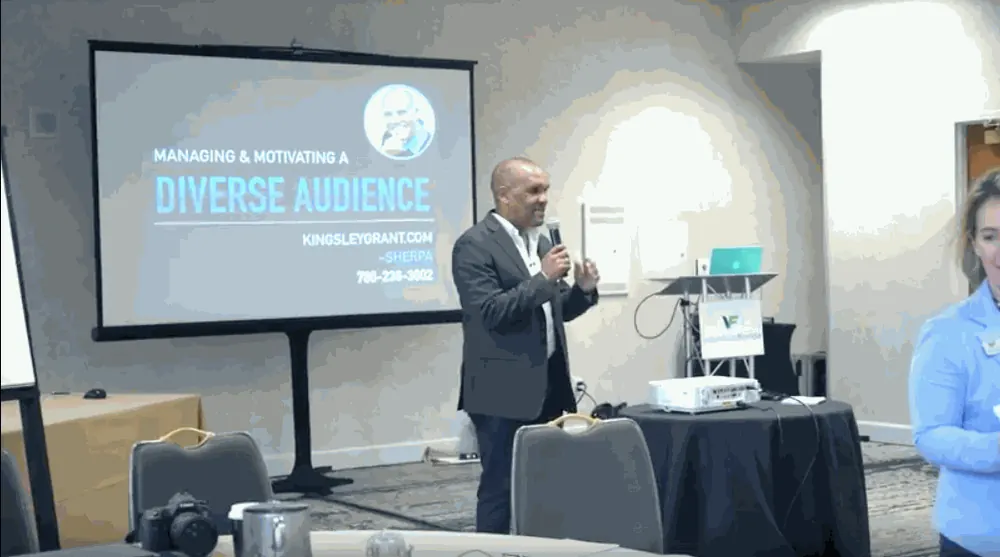 Kingsley Grant speaking into a microphone in front of an audience