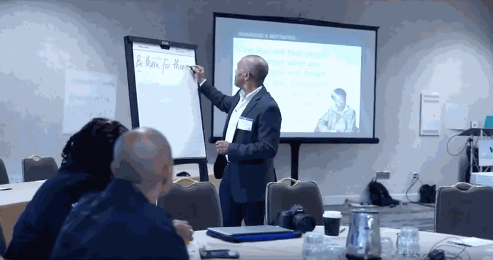 Kingsley Grant writing on a flip chart during a training